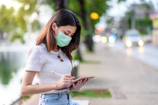 Empresaria asiática sentada en el uso de mascarilla quirúrgica