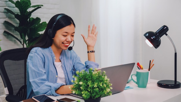 Empresaria asiática trabajando desde casa con ordenador portátil