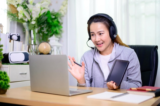 Empresaria asiática trabajando en línea en casa. Estilo de vida de la mujer tailandesa en la sala de estar. Distanciamiento social y nueva normalidad.