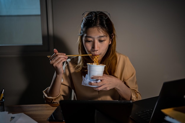 Empresaria asiática trabajando en línea por la noche. Ocupado y agotado de horas extras de trabajo en casa