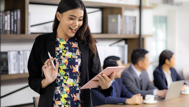 Empresaria asiática trabajando con tableta inteligente