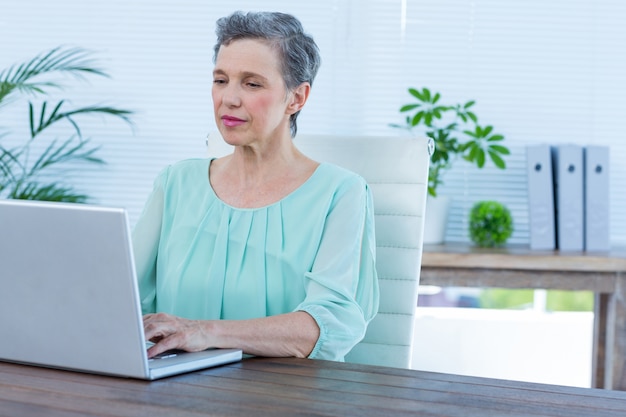 Empresária atenta trabalhando em seu laptop