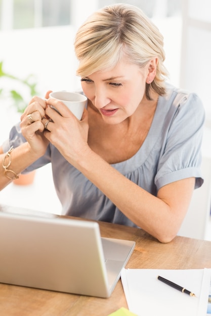 Empresária atenta trabalhando em um laptop