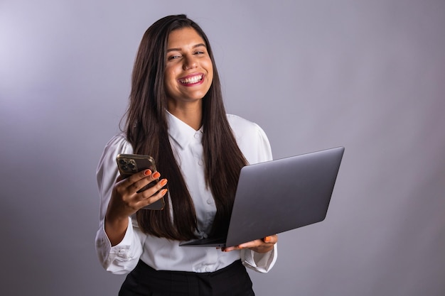 Empresaria brasileña con portátil y teléfono inteligente