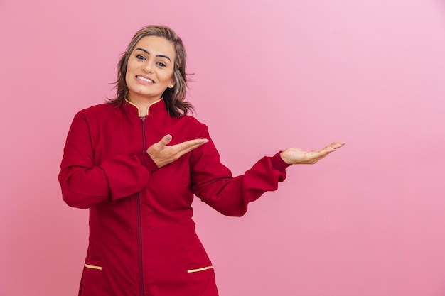 Empresaria brasileña profesional estética con un abrigo rojo apuntando hacia un lado que indica un producto que presenta algo publicitario