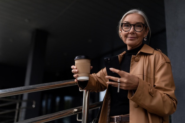 Empresária caucasiana madura com uma xícara de café lá fora