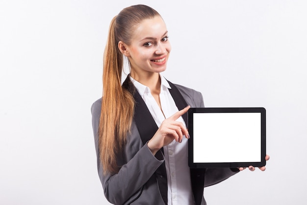 Foto empresaria caucásica atractiva joven en tableta vacía del control gris del traje