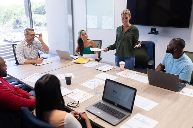 Foto empresaria caucásica sonriente explicando la estrategia durante una reunión en la sala de juntas del lugar de trabajo