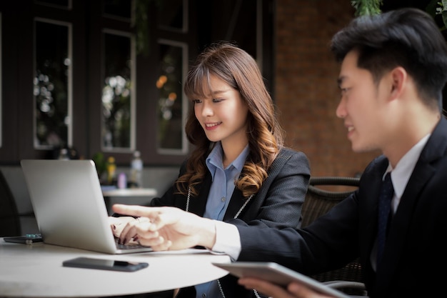 Empresaria con colega usando laptop