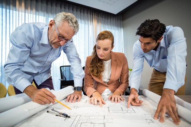 Foto empresaria y compañeros de trabajo discutiendo blueprint