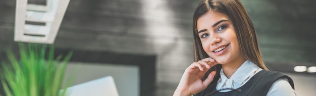 La empresaria con una computadora portátil sentada en el escritorio