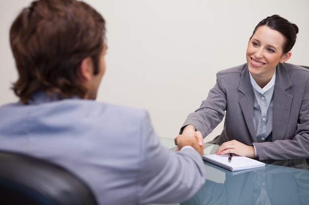 Empresaria da la bienvenida al cliente en su oficina