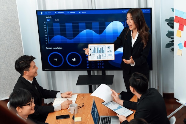 La empresaria da una presentación sobre los datos del tablero en la pantalla en la oficina de armonía