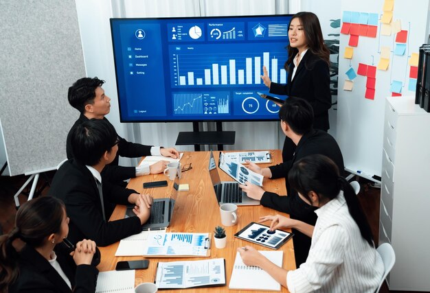 La empresaria da una presentación sobre los datos del tablero en la pantalla en la oficina de armonía