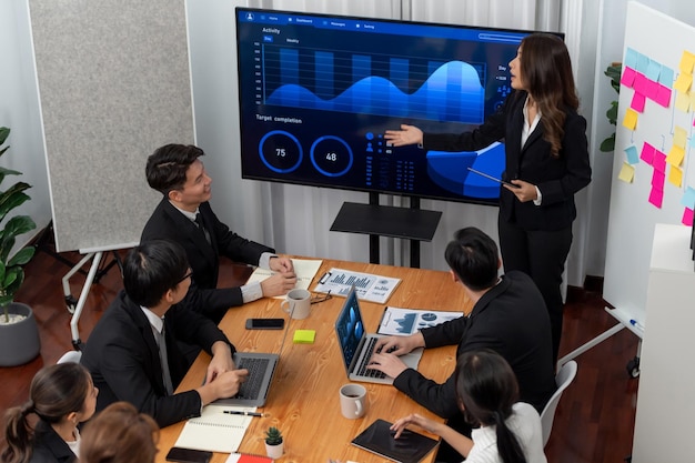 La empresaria da una presentación sobre los datos del tablero en la pantalla en la oficina de armonía