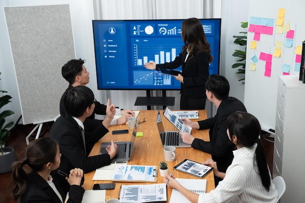 La empresaria da una presentación sobre los datos del tablero en la pantalla en la oficina de armonía