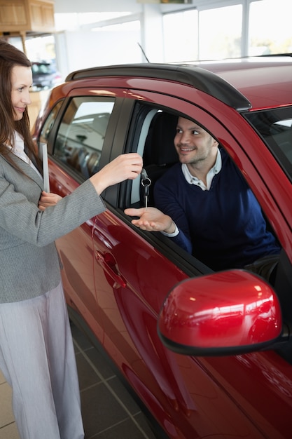 Empresaria dando las llaves del coche a un cliente