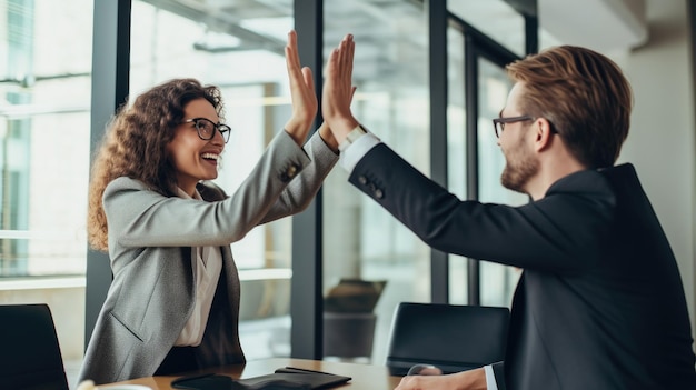 Empresária dando um high five para um colega do sexo masculino em reunião com profissionais de negócios high five durante uma reunião na sala de reuniões