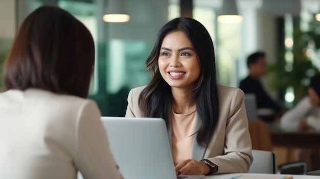 Empresária de grupo maduro tailandês usando sorriso de laptop conversando com um amigo no escritório branco