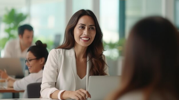 empresária de grupo maduro usando sorriso de laptop conversando com um amigo no escritório branco