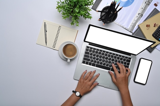 Empresária de visão aérea trabalhando com laptop na mesa de escritório branca