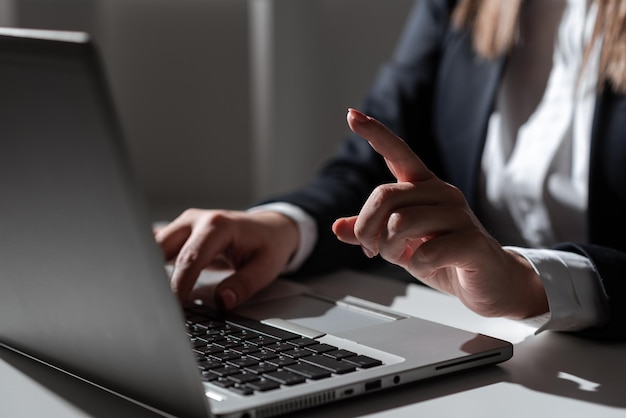 Empresária digitando atualizações recentes no teclado Lap Top na mesa com celular e apontando ideias importantes Mulher de um dedo no escritório escrevendo mensagens atrasadas no computador