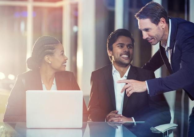 Empresária discutindo com os colegas sobre laptop