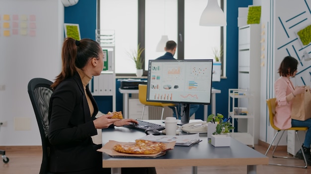 La empresaria disfrutando de comida orden de comida en la oficina de la empresa durante el almuerzo para llevar