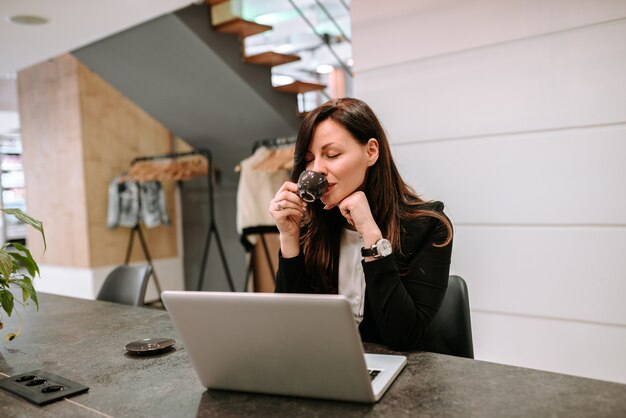 Empresaria disfrutando de una taza de café.