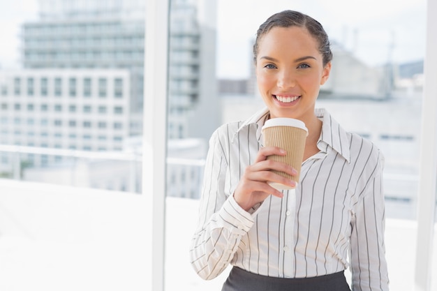 Empresaria divertida sosteniendo un café