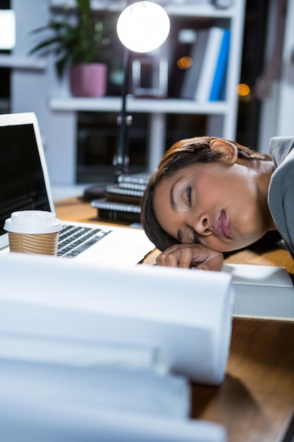 Foto empresária, dormindo enquanto trabalhava no escritório