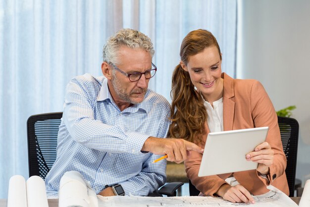 Empresária e colega de trabalho interagindo usando tablet digital