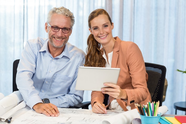 Empresária e colega de trabalho interagindo usando tablet digital