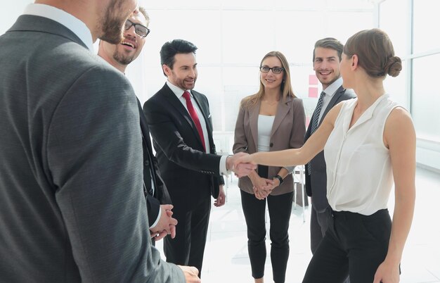 Foto empresária e homem apertando as mãos no escritório