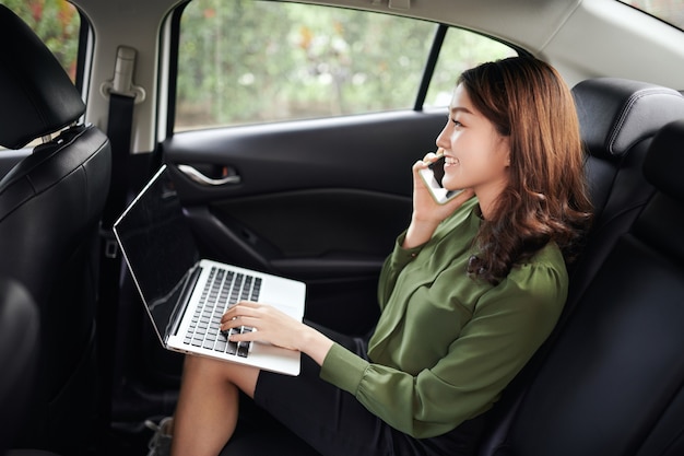 La empresaria ejecutiva en coche trabaja en su computadora portátil.