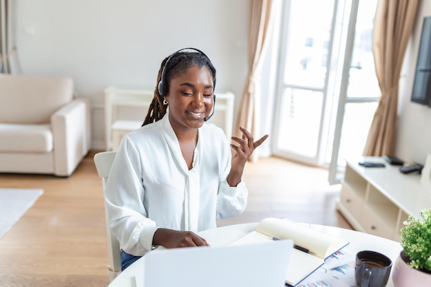 Empresária elegante afro-americana discutindo enquanto faz uma teleconferência Retrato de funcionária de etnia confiante olhando para a câmera do laptop falando em videochamada no escritório em casa
