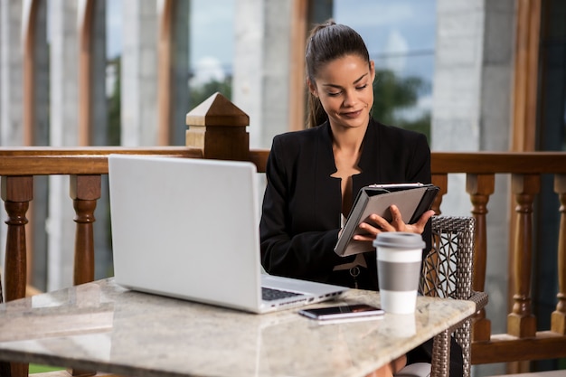 Empresária elegante com gadgets na mesa