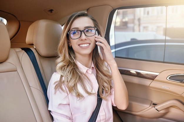 Empresária em óculos falando no smartphone