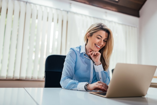 Empresaria encantadora que usa la computadora portátil.