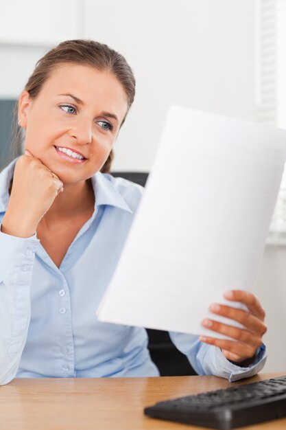 Empresária encantadora sorrindo para um papel