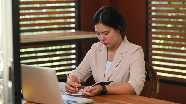 Empresária, escrevendo no papel de bloco de notas.