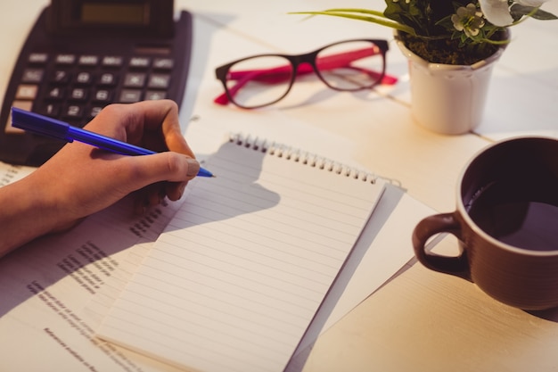 Empresaria escribiendo notas en el libro