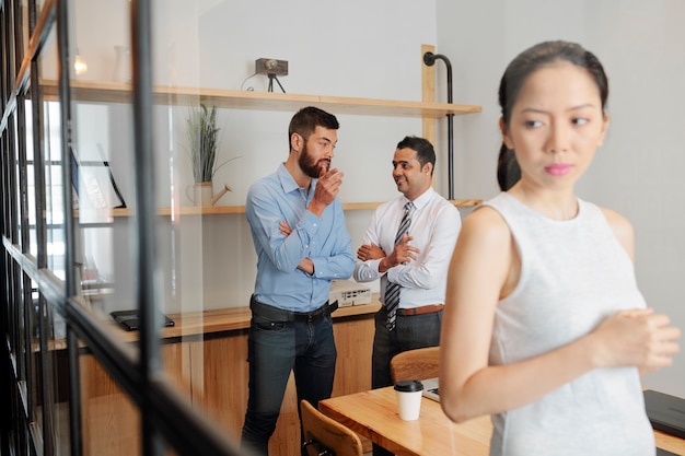 Empresaria escuchando hablar de dos empresarios