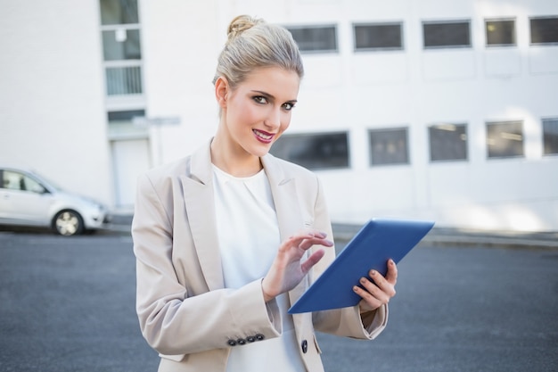 Empresaria con estilo alegre que se desplaza en la tableta digital