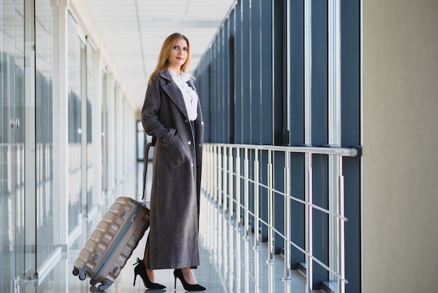 Empresaria con estilo con equipaje en el aeropuerto