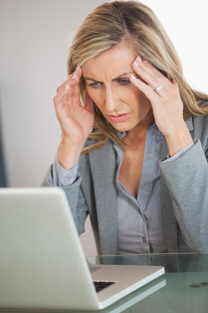 Empresária estressada tentando usar seu laptop