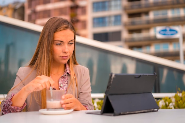 Empresária executiva loira ou mulher financeira tomando um café da manhã descafeinado com seu tablet