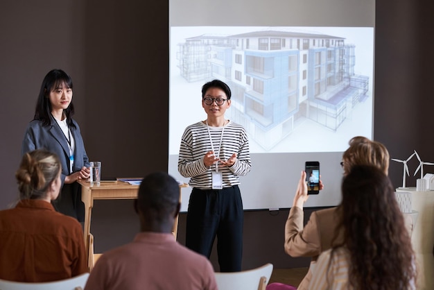 Empresaria exitosa asiática hablando sobre el nuevo proyecto arquitectónico durante la presentación para empresarios