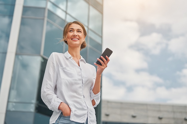 La empresaria exitosa mujer de negocios persona de pie exterior exterior del edificio corporativo