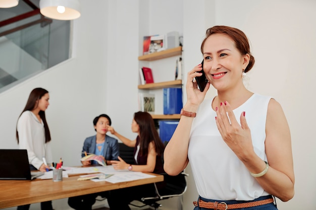 Empresária, falando ao telefone no escritório